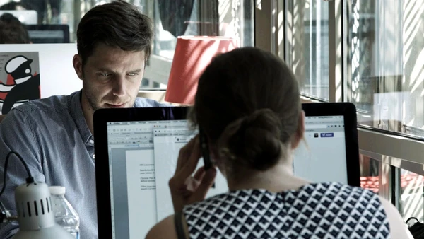 Two people work at computers in "Depuis Mediapart".