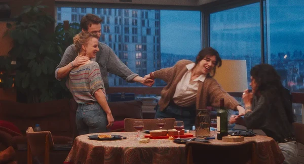 Characters joyfully gather indoors in "Les Passagers de la nuit".