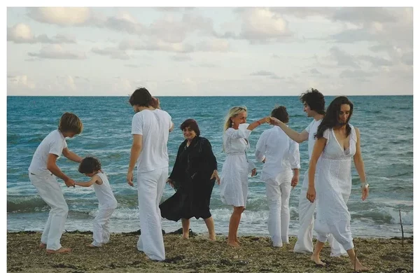 People in white clothes interact on beach in "Les plages d'Agnès".