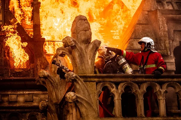 A firefighter works on a balcony amidst the flames of Notre-Dame in "Notre-Dame brûle".