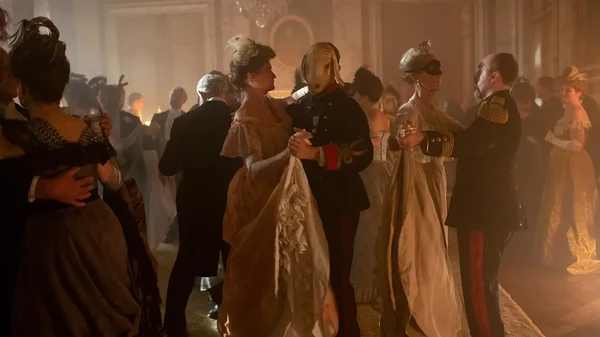 People dance at a masquerade party amidst the chaos of Paris in "Paris Police 1900 Season 1".